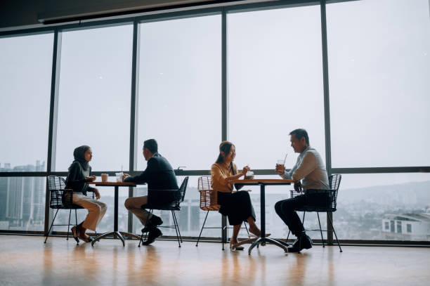 istock Coffee break Asian white collar colleague discussion with window background 2187240809