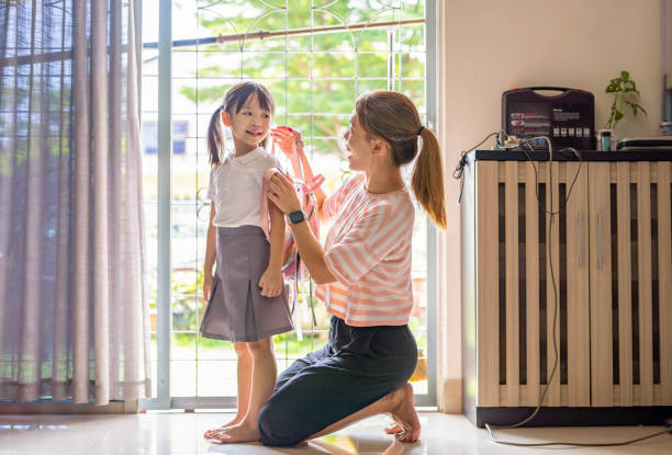 istock Mother helping daughters backpacks for school 2187240826