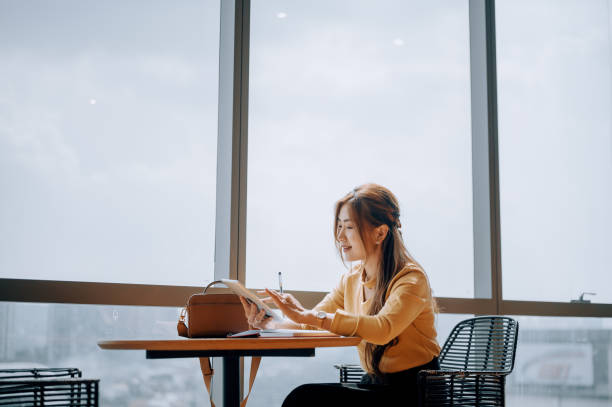 istock An Asian Business Women using tablet  at office lounge during coffee break 2187240844