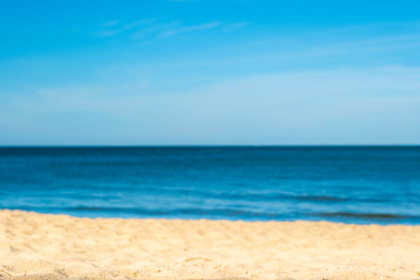 Beach sand background for summer vacation concept. Beach nature and summer seawater with sunlight light sandy beach Sparkling sea water contrast with the blue sky.