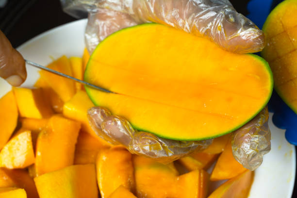 istock Close-Up Hands Slicing a Ripe Mango Fruit - Healthy and Fresh Snack Preparation 2187241904