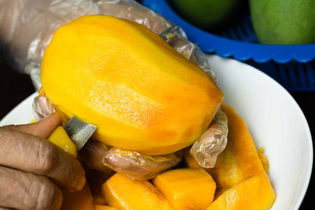 istock Close-Up Hands Slicing a Ripe Mango Fruit - Healthy and Fresh Snack Preparation 2187241910