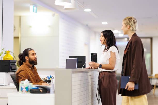 istock Two female colleagues at being greeted at reception desk of co-working space 2187242757