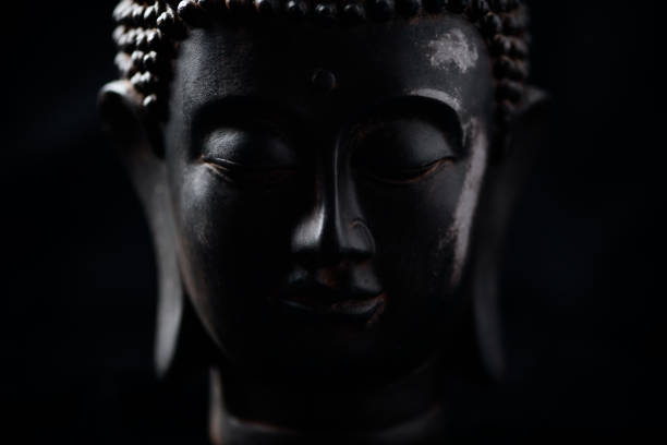 Meditating Buddha Statue on dark background. Soft focus. Close up. Copy space.