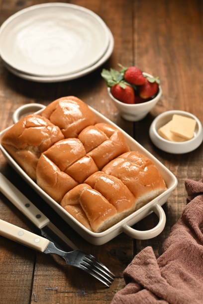 Japanese milk bread: soft, fluffy white bread loaf served on white plate accompanied by a plate of strawberries.