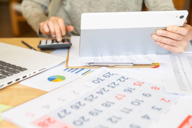 istock Woman At Home Managing Tasks With Tablet And Calendar,Scheduling Appointments,Organizing Events,Paying Bills,Meeting Deadlines,Setting Goals And Improving Time Management And Personal Efficiency 2187248732