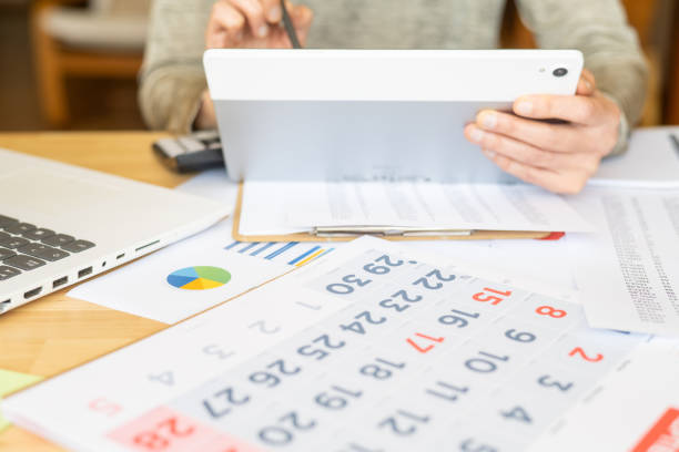 istock Business-Oriented Woman Taking Notes In Calendar With Tablet At Home,Planning Events,Scheduling Deadlines,Organizing Goals,Managing Finances,Paying Bills And Enhancing Overall Productivity And Focus 2187248739
