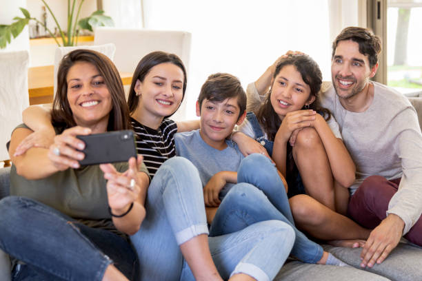 istock Happy family taking selfie together on sofa at home 2187249864