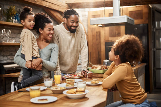 istock Happy black family enjoying in breakfast in the kitchen. 2187250022