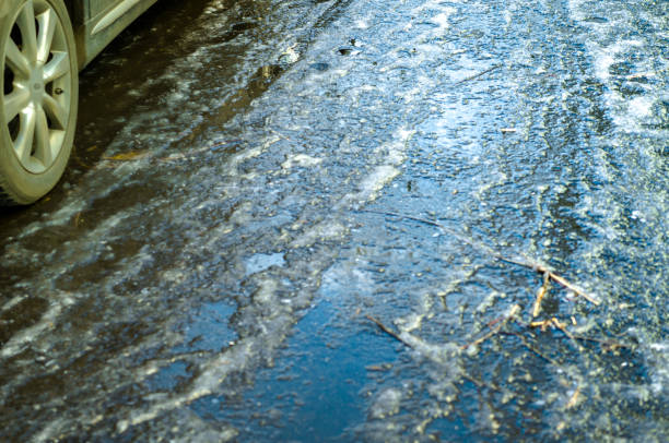 istock icy road and salt grit 2187250155