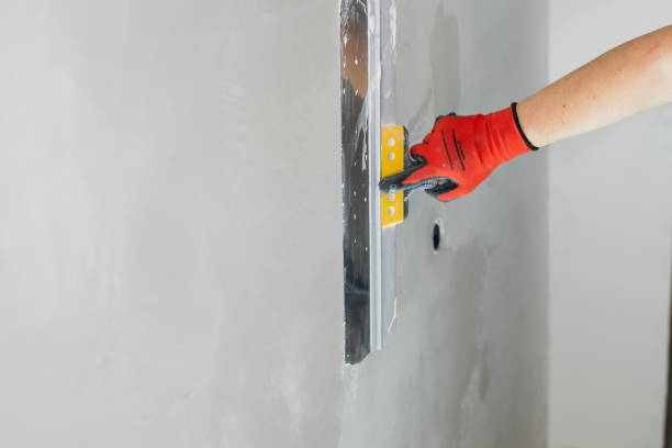 istock The hand of a craftsman with a spatula during work on leveling a wall with putty 2187251732