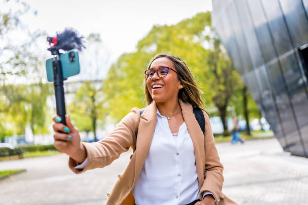 istock Latin woman vlogging while walking along the city 2187252361