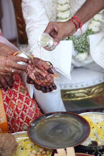 istock Groom pours a sacred liquid into the bride's hand. 2187252535