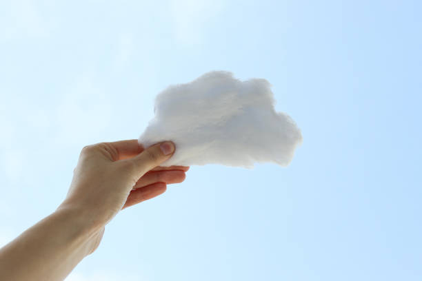 istock A cloud of cotton wool in his hand against the sky 2187256177