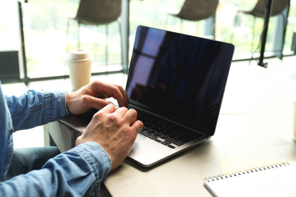 istock Man working laptop, coffee cup and notebooks on table in coworking space, close up 2187257561