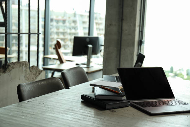 istock Office table by the window with coffee, laptop and notebooks 2187257595