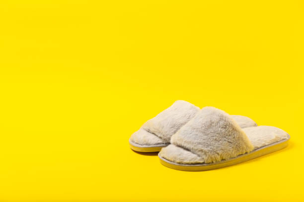 A pair of grey slippers on a rustic wood background