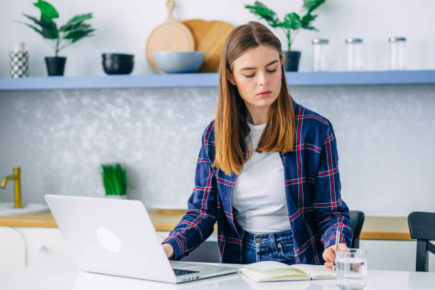 istock serious young woman freelancer working on the computer at home. 2187261326