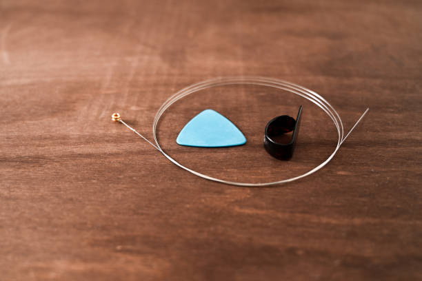 istock essential guitar accessories - thumb pick, plectrum and a spare steel string 2187261376