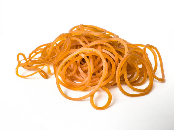 istock A pile of orange rubber bands on a clean white background. 2187264024