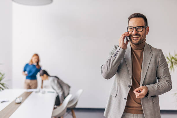 istock A smiling manager is talking on his smartphone in a business hall 2187264230