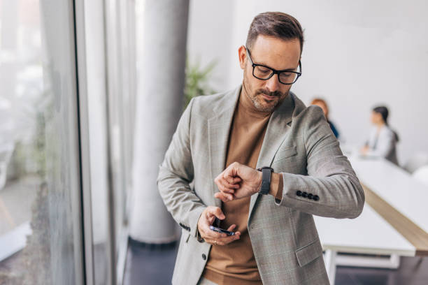 A businessman is checking the time in the office.
