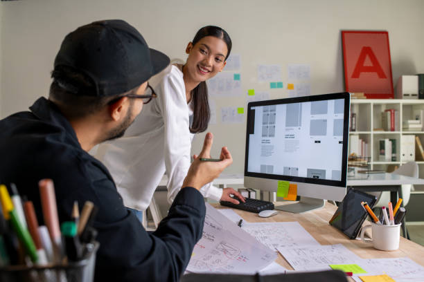 istock UX UI designers discussing and brainstorming on wireframes for a website and mobile app prototype, surrounded by sketches of user flow and design tools, in the concept of website and mobile application design concept. 2187265578