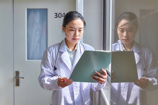 istock Asian Female Doctor Examining Data by the Window 2187265998