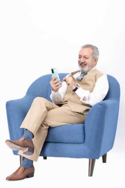 istock Senior man using laptop sitting on sofa isolated white background stock photo 2187267279