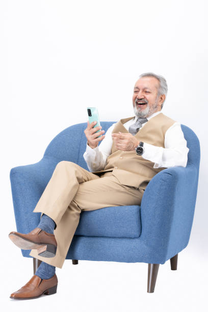 istock Senior man using laptop sitting on sofa isolated white background stock photo 2187267336