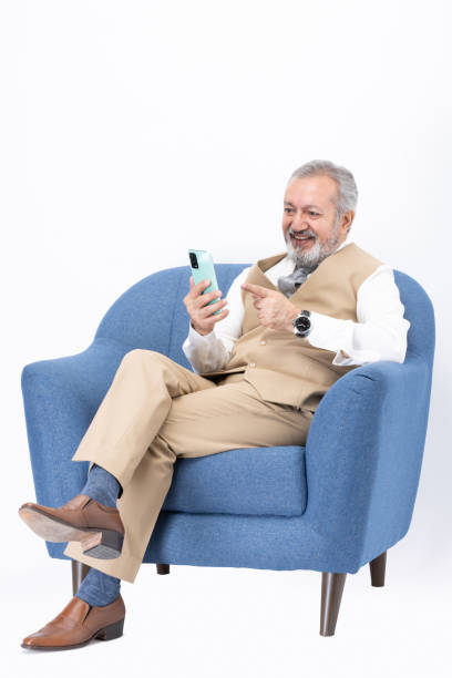istock Senior man using laptop sitting on sofa isolated white background stock photo 2187267376