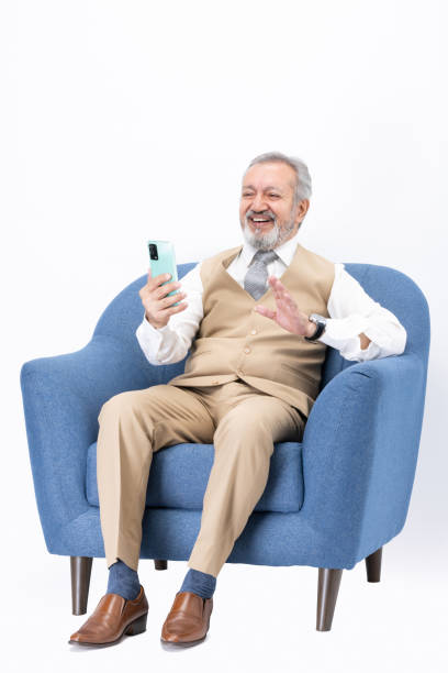 istock Senior man using laptop sitting on sofa isolated white background stock photo 2187267512