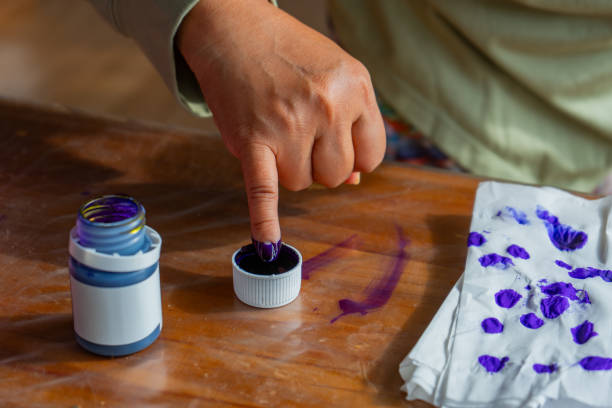 Inonesian voter dipping hand to purple electoral ink at 2024 mayoral and governorship election, the purpose is for preventing electoral fraud