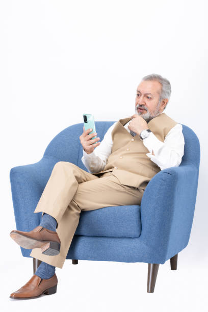 istock Senior man using phone sadness sitting on sofa isolated white background stock photo 2187269481