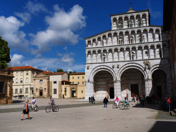 Lucca, Italy - May 31, 2024: Tourism and cycle touring in Tuscany. Tourists visit Lucca Cathedral