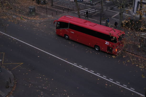 A red coach waiting on a Parisian avenue. Paris, France - November 24, 2024