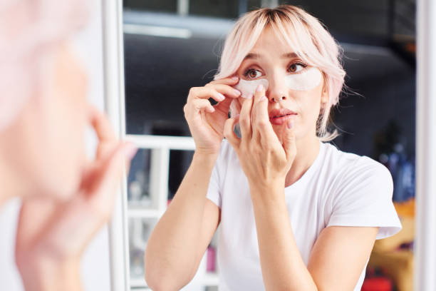 istock Young woman putting under eye treatment patches on 2187273931