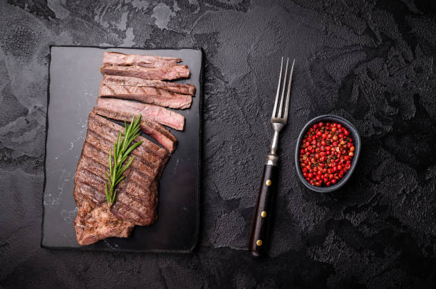 istock Grilled medium beef Rump steak on marble board. black background. top view 2187275321