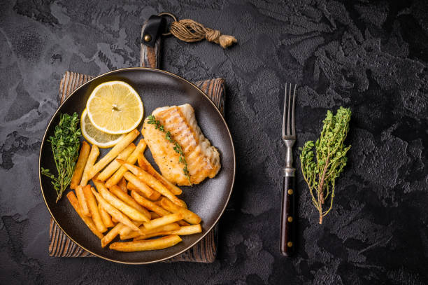 istock Homemade Fish and chips with roast cod whitefish fillet and fried potatoes on plate. black background. top view 2187275439