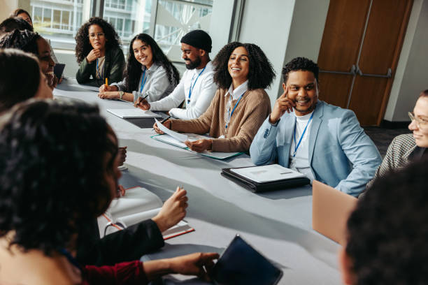 istock Diverse group of professionals in a seminar setting, engaging in lively discussion around a conference table 2187278697