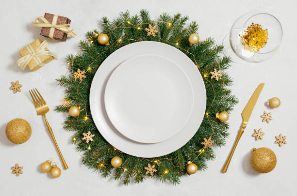 istock Christmas serving with empty plate and gold decorations on white background. New Year party. Festive table setting for the new year. View from above. 2187278716