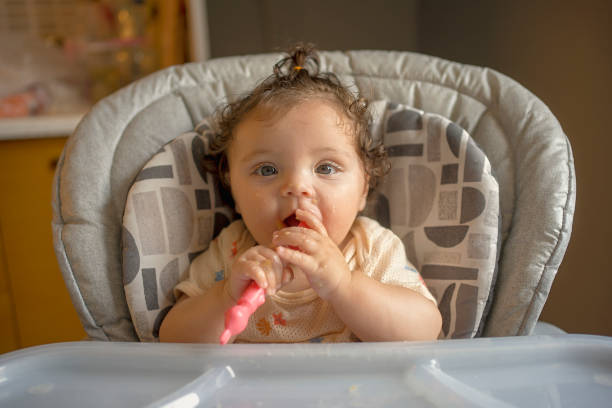 istock Adorable Baby Enjoying Mealtime with Spoon 2187281443