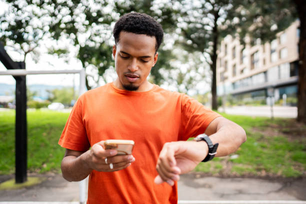 istock Sportsman using smart watch and mobile phone at public park 2187282726