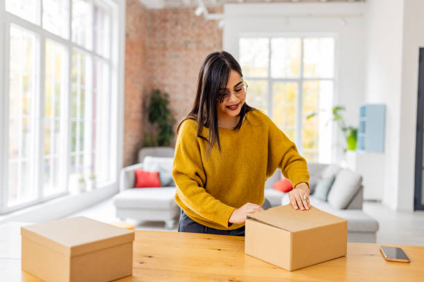 istock Content woman closes box after checking striped shirt. 2187286710