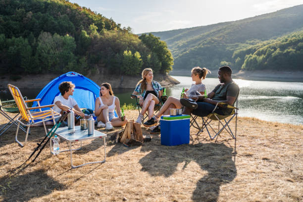 istock Group of friends camping together by a lake 2187288075