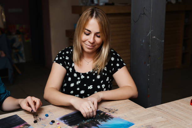 istock Woman working on a creative project at a wooden table in a cozy setting 2187289388