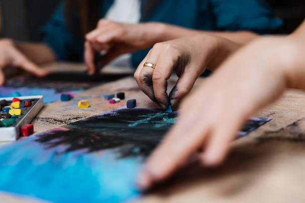 istock Engaged artists creating vibrant pastel drawings at a creative workshop 2187289820