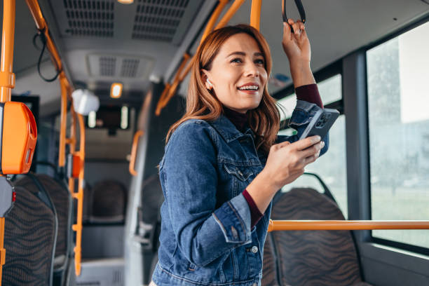 istock Cheerful woman using smartphone and earbuds on bus during commute 2187291042