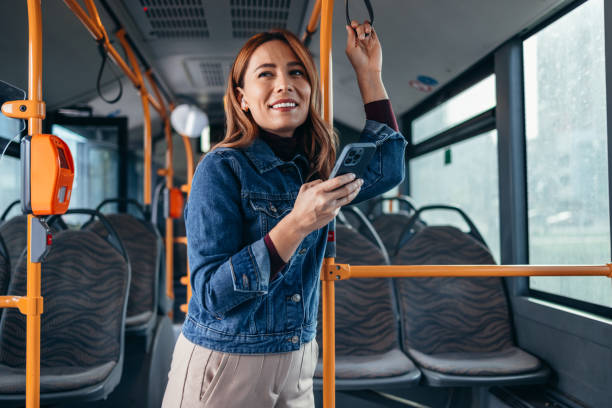 istock Cheerful woman using smartphone and earbuds on bus during commute 2187291078