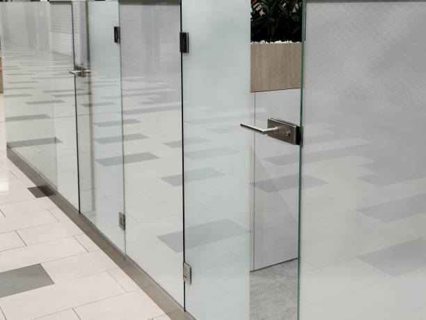 frameless glass door. glazed partitions have special hinges and handles. everything is drilled into the glass and attached with stainless steel screws. polished bar handle frameless glass door. glazed partitions have special hinges and handles. everything is drilled into the glass and attached with stainless steel screws. polished bar handle, lobby frosted glass door office stock pictures, royalty-free photos & images